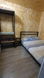 - une chambre avec 2 lits et un mur en bois dans l'établissement Afrodita Hotel, à Stepanavan