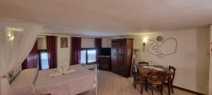 1 dormitorio con cama, mesa y comedor en Monolocale in via pedonale, en Saint Vincent