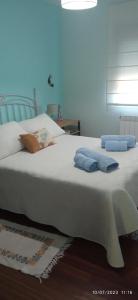 a bedroom with a white bed with blue towels on it at leiradaporta in Monforte de Lemos