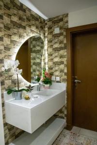 bagno con lavandino bianco e specchio di صالة وغرفتين نوم دخـول ذاتي ad Al Kharj