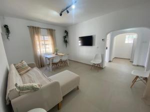 a white living room with a couch and a table at Villa Alegría in Chiclana de la Frontera