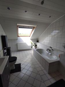 La salle de bains est pourvue d'une baignoire, de toilettes et d'un lavabo. dans l'établissement Ferienwohnung im Grünen, à Geldern