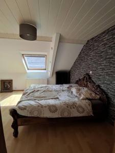 - une chambre avec un lit et un mur en briques dans l'établissement Ferienwohnung im Grünen, à Geldern