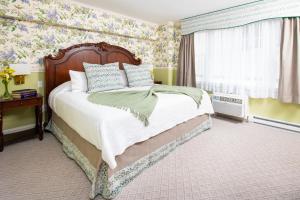 a bedroom with a large bed with floral wallpaper at America's Cup Inn Newport in Newport