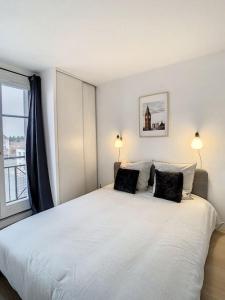 1 dormitorio con 1 cama blanca grande y 2 almohadas en Maison du ciel, Aéroport, Paris, en Villeparisis