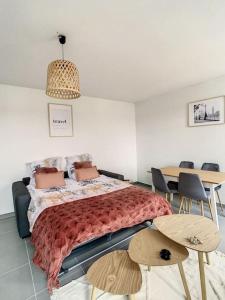 1 dormitorio con 1 cama, mesa y sillas en Maison du ciel, Aéroport, Paris, en Villeparisis