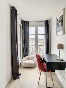 維勒帕里西的住宿－Maison du ciel, Aéroport, Paris，客厅配有黑色的办公桌和红色的椅子