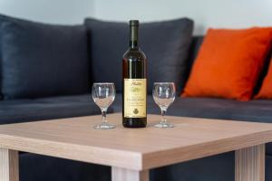 - une bouteille de vin assise sur une table avec deux verres dans l'établissement Petrovac Holiday Apartments 2, à Petrovac na Moru