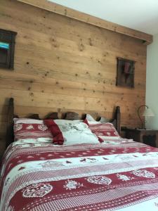 a bed in a room with a wooden wall at Casa Vauterin in La Thuile