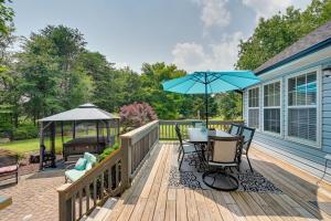 a deck with a table and chairs and an umbrella at 1-Acre Family Home with Pool about 11 Mi to Greensboro in Monticello