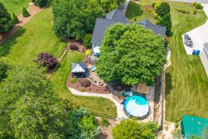 an aerial view of a house with a swimming pool and trees at 1-Acre Family Home with Pool about 11 Mi to Greensboro in Monticello