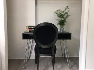 een zwarte stoel aan een bureau met een plant bij SELAH 4 Bedroom house close to Everything in Miami in Miami