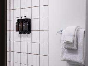 a bathroom with white tiled walls and white towels at Trailborn Rocky Mountains Outpost in Estes Park