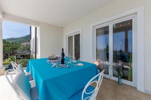 uma mesa com uma toalha de mesa azul numa varanda em Apartments Chiara mit Meerblick und Pool em Lovran