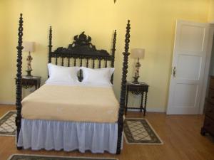 a bedroom with a large bed and two night stands at Quinta do Canto in Horta