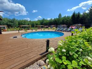 a swimming pool on a wooden deck with a yard at NA KOŃCU WSI in Ruciane-Nida