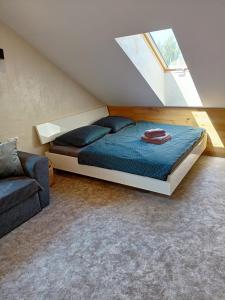 a bedroom with a bed and a couch and a window at Apartmán u Ovečků - Nová Paka in Nová Paka
