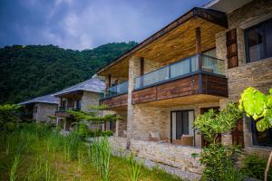 een stenen huis met een balkon op een heuvel bij Dorje's Resort and Spa in Pokhara