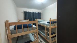 a small room with two bunk beds and a mirror at Apartamento Inteiro in Blumenau