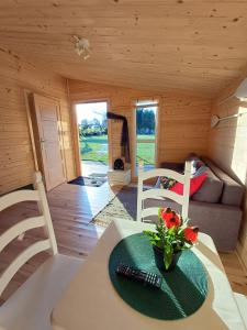 ein Zimmer mit einem Tisch und Stühlen in einer Hütte in der Unterkunft NA KOŃCU WSI in Ruciane-Nida