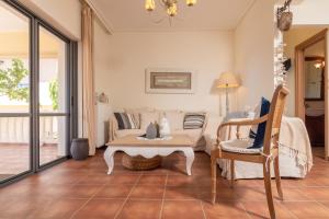 sala de estar con sofá, mesa y sillas en Marika Seaside Villa, en Yialós