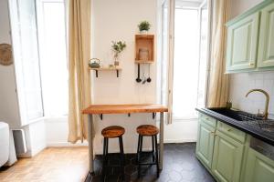 a kitchen with a counter and two stools at Une Pause quelque part in Marseille