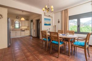 uma cozinha e sala de jantar com mesa e cadeiras em Marika Seaside Villa em Yialós