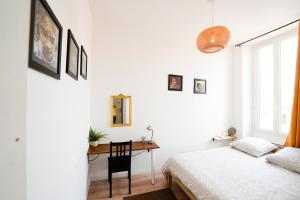 a bedroom with a bed and a desk and a window at Une Pause quelque part in Marseille +3 photos