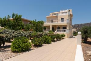 una casa grande con una pasarela delante de ella en Marika Seaside Villa, en Yialós