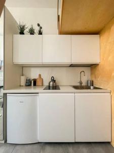 uma cozinha com armários brancos e um lavatório em Small studio with entresol em Bydgoszcz