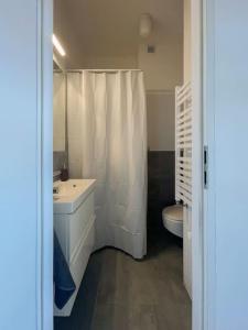 uma casa de banho branca com um lavatório e um WC em Small studio with entresol em Bydgoszcz