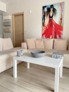 uma sala de estar com um sofá e uma tigela sobre uma mesa em Sweet Makri Suite em Nea Makri