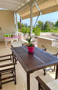 a wooden table with a potted plant on a patio at Sweet Makri Suite in Nea Makri