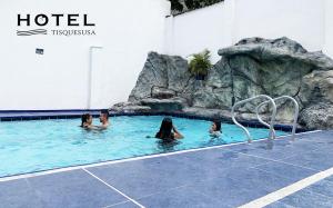 a group of people in a pool at a hotel at El Hotel Tisquesusa in Girardot