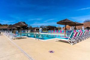 a swimming pool with lounge chairs and umbrellas at Mobil-homes emplacement 732 en 3ch ou 828 en 4ch tout équipés proche océan in Gastes