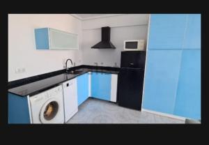 una cocina con lavadora y nevera en Edificio El Sol, en Cullera