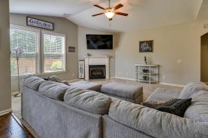 a living room with a large couch and a fireplace at Cozy South Carolina Retreat with Patio and Fireplace! in Greenville