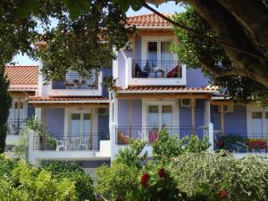 a building with balconies in front of it at Villa Eliza in Skala +20 photos