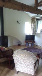 sala de estar con sofá y silla en Millstone cottage, en Oldham