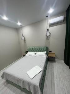 a bedroom with a large bed with two lamps at Люксовая Квартира in Aktobe