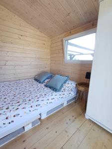a bed in a wooden cabin with a window at NA KOŃCU WSI in Ruciane-Nida +20 photos