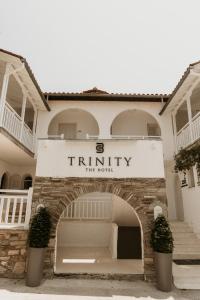 a building with a sign that reads trinity the hotel at TRINITY THE HOTEL in Ammouliani