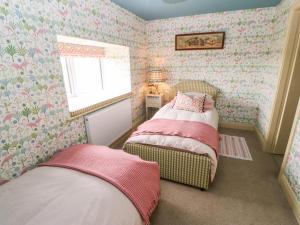 a small bedroom with two beds and a window at The Granary in Morpeth