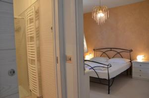 a bedroom with a bed and a chandelier at Elena Apartment - View Lake - Private Garage in Bardolino