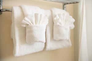 three towels hanging on a towel rack in a bathroom at America's Cup Inn Newport in Newport