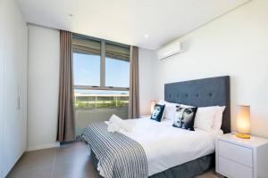 a bedroom with a large bed and a large window at Pebblebeach 2 bedroom Apartment in Sibaya