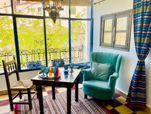 a living room with a table and a chair and windows at Casa Amigos Sorvilan- La Palmera in Sorvilán