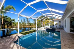 a swimming pool with a white pergola and a swimming poolvisor at Villa Bremen - Pool / Spa Home in Cape Coral