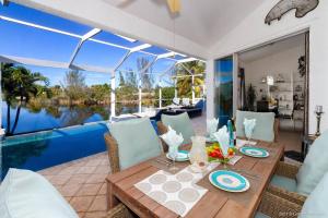 a dining room with a table and a view of the water at Villa Bremen - Pool / Spa Home in Cape Coral