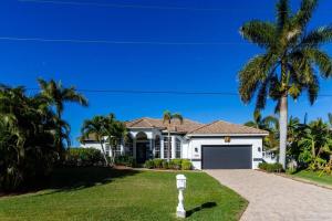 a white house with palm trees and a driveway at Villa Bremen - Pool / Spa Home in Cape Coral